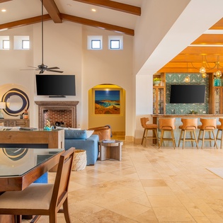 Settle into your spacious open-plan living area where warm wood beams and stylish furnishings create the perfect backdrop for memorable vacation moments.