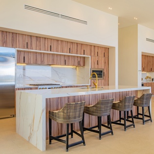 Your gourmet kitchen awaits with marble waterfall island, professional appliances, and stylish seating for memorable meal prep and casual dining.