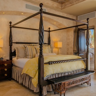 Drift into luxury beneath your elegant canopy bed, where warm lighting and desert views create the perfect retreat.