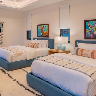Sink into crisp white linens and rest your head on plush pillows after a day exploring the area. Vibrant wall art and soft textures create a welcoming space where you'll feel right at home.