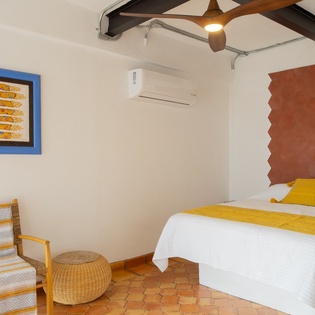 Relax in your beautifully appointed bedroom featuring vibrant artwork, comfortable seating, and modern amenities for a perfect getaway.
