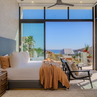 Wake up to stunning ocean views through floor-to-ceiling windows in your luxurious bedroom retreat.