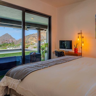 Wake up to sweeping mountain views from your private bedroom, where floor-to-ceiling windows frame the dramatic desert landscape. Modern comfort meets artistic touches in this serene retreat.