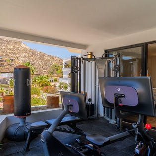 Stay active on vacation with this fully-equipped fitness area, featuring mountain views and professional-grade equipment for your daily workout routine.
