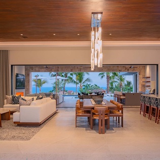 Step into an open living space designed for relaxation and entertaining. Enjoy stunning ocean views through floor-to-ceiling windows while you unwind in the lounge or gather around the dining table with your favorite people.