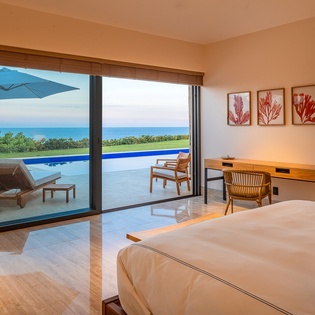 Bedroom suite with ocean views and patio access