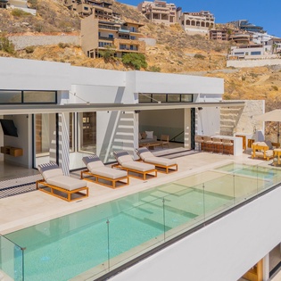 Modern architectural villa nestled in hillside terrain, featuring contemporary design and panoramic views of the surrounding landscape.