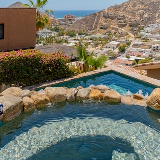 Stone patio with sun deck and pool