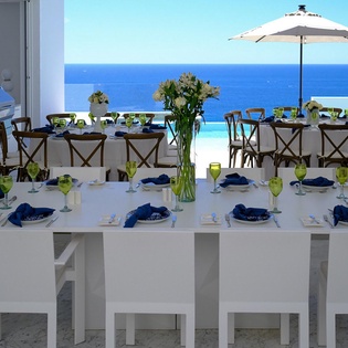 Dine with endless ocean views from your private terrace, where elegant blue and white table settings await memorable meals.
