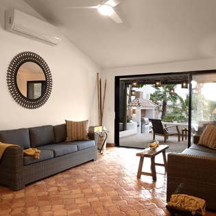 Unwind in your stylish living space with terracotta floors and air conditioning, where large windows flood the room with natural light.