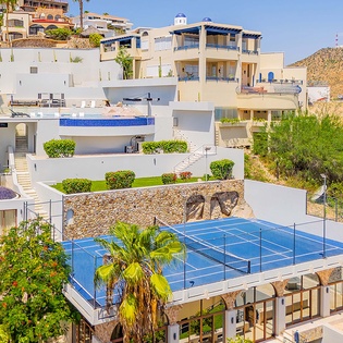 Hillside vacation properties with tennis facilities and pool areas, situated in a coastal neighborhood surrounded by natural desert landscape.