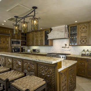 Step into your gourmet kitchen where ornate carved cabinetry and gleaming granite create an elegant culinary haven for memorable meals.