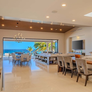 Modern open-concept living flows seamlessly to your oceanfront terrace, where warm wood tones and coastal breezes blend for effortless indoor-outdoor living at its finest.