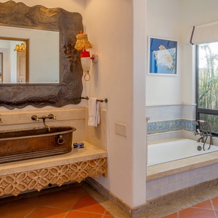 En suite bathroom with double sink and bath tub