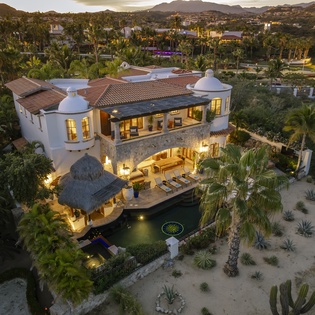 Luxury villa with private pool and palapa in scenic mountain valley setting with desert landscaping and tropical vegetation.