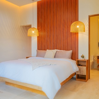 Unwind in your serene bedroom with warm wood accents and pendant lighting creating a peaceful retreat for restful nights.