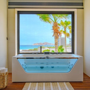 En suite bathroom with bath tub and ocean views