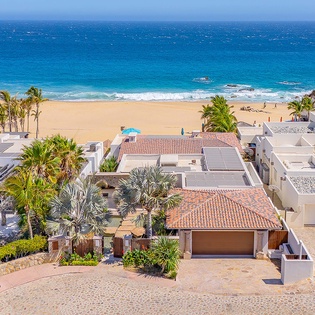 Stunning beachfront property offering direct access to pristine golden sands and crystal-clear turquoise waters, surrounded by swaying palms and coastal beauty in an exclusive neighborhood.
