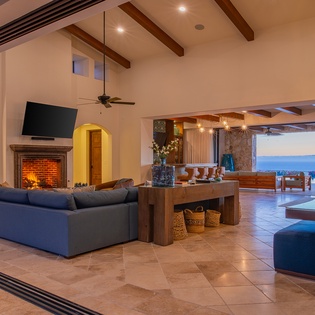 Sink into plush sofas by your crackling fireplace while colorful lanterns cast a magical glow over this stunning open-plan living space.