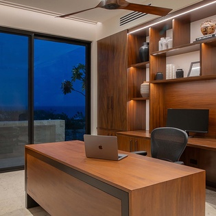 Your private workspace blends modern elegance with warm wood tones, featuring custom built-ins, ambient lighting, and large sliding doors opening to a serene outdoor terrace—perfect for focused work or quiet reflection.