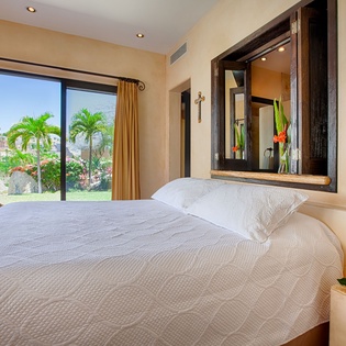 Wake up to tropical palm views from your plush bed. This serene bedroom offers garden vistas, warm decor, and thoughtful touches for your perfect getaway.