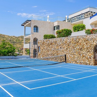 The property features a private tennis court framed by mountains and Mediterranean charm—perfect for an active morning or friendly match during your stay.