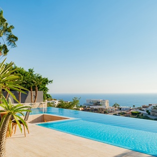 Sunny patio with infinity pool and ocean view