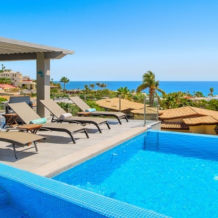 Soak up endless blue skies from your private pool terrace, where comfortable loungers await and ocean views stretch beyond swaying palms.
