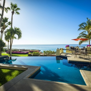 Your infinity pool merges seamlessly with turquoise ocean waters, framed by swaying palms and tropical paradise.