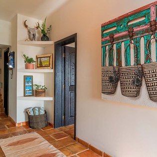 A vibrant entryway welcomes you with handcrafted décor, curated shelves, and rustic tilework that sets a warm, authentic tone for your stay.