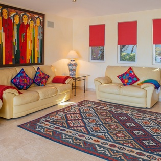 Settle into your bright living room where vibrant artwork and colorful pillows create a welcoming atmosphere for relaxation.