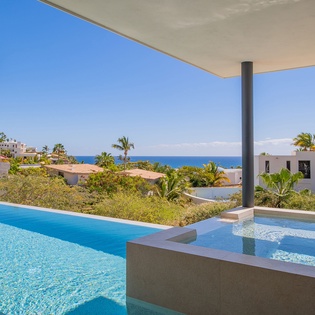 Your private infinity pool overlooks stunning ocean views through swaying palms, creating the perfect tropical escape for relaxation.