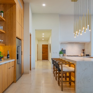 Your culinary dreams come alive in this stunning modern kitchen with sleek marble island, warm wood cabinetry, and designer lighting.
