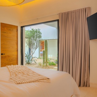 Wake up to your private desert garden courtyard through floor-to-ceiling windows that frame cacti and native plants perfectly.