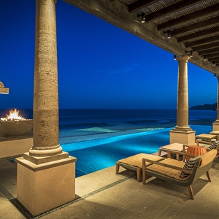Unwind on your private terrace where infinity pool meets ocean, columns frame starlit skies, and poolside loungers await your evening retreat.