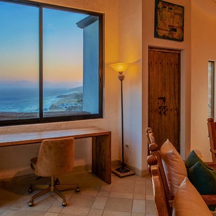 Your cozy workspace overlooks stunning ocean and coastal views at sunset, blending warm Southwestern charm with inspiring natural beauty just outside your window.