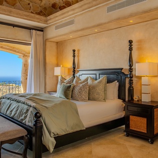 Wake up to stunning ocean views from your luxurious bedroom, where elegant furnishings and warm lighting create the perfect retreat for peaceful nights.