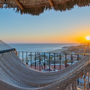 Sway gently in your private hammock as golden sunsets paint the ocean horizon, creating your perfect evening retreat.