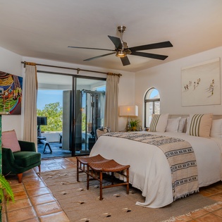 Relax in your bright, thoughtfully designed bedroom with direct patio access and stunning natural light. Unwind beneath the ceiling fan, surrounded by vibrant art and cozy furnishings that welcome you home.