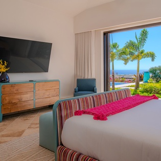 Wake up to stunning tropical views from your comfortable bed, with palm trees swaying beyond your window and vibrant ocean scenery stretching to the horizon.