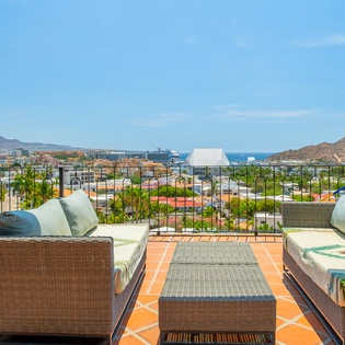Sink into plush terracotta-tiled seating and soak up sweeping views of Cabo's coastline, mountains, and marina—your perfect perch for morning coffee or sunset cocktails.