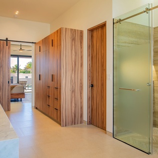 Step into your luxurious ensuite with sleek glass shower, rich wood cabinetry, and polished marble surfaces.