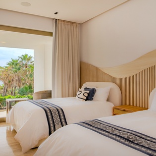 Wake up to tropical palm views in your serene twin bedroom, where modern comfort meets warm wood design.