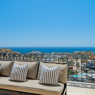 Relax on your private terrace with stunning ocean views and luxurious seating, where striped cushions invite endless comfort.