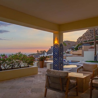 Sink into plush seating on your private terrace and soak in the breathtaking coastal sunset—your peaceful retreat with stunning ocean and hillside views awaits.