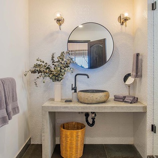 Step into this beautifully styled bathroom where warm lighting and natural textures create a serene retreat after your adventures.