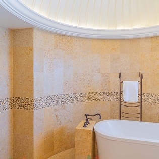 Sink into relaxation in your private soaking tub, surrounded by elegant stone finishes and soft lighting beneath a stunning domed ceiling.