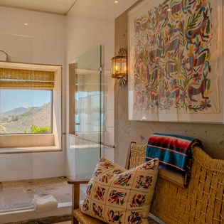 Unwind in your beautifully appointed bathroom featuring vibrant artwork, mountain views, and artisanal details that create a serene spa-like retreat.