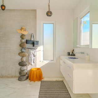 Step into your spa-like sanctuary with a rainfall shower, floating vanity, and artful stone sculptures creating zen vibes.
