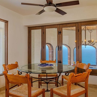 Picture yourself dining with breathtaking ocean views framing every meal. The warm wooden furnishings and elegant glass table create an inviting space where your vacation moments become memories.